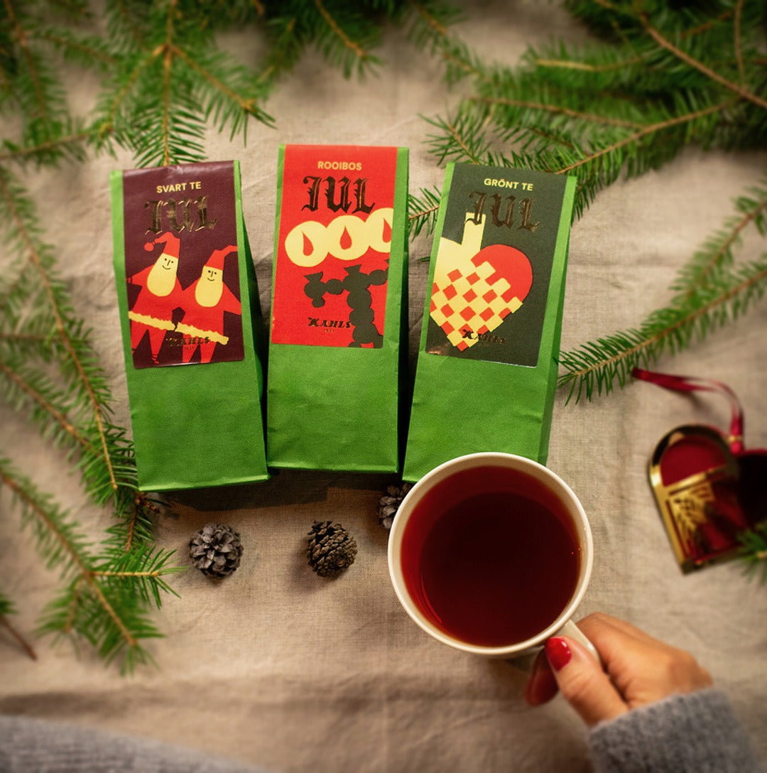 Kahls tre julteer bland granris med en kopp te